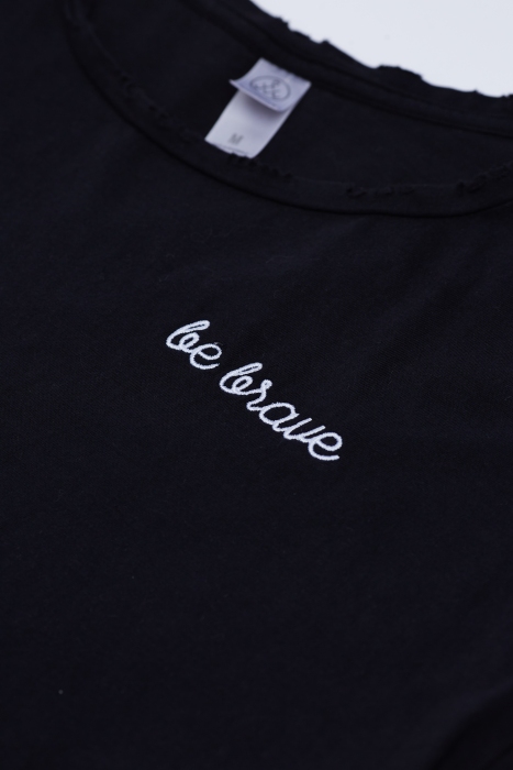 Close up of 'Be Brave' text embroidered on black t-shirt